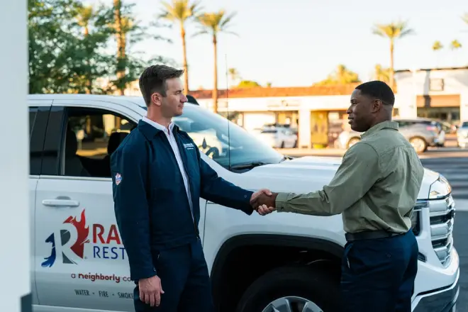 Rainbow Restoration professional shaking hands with a client.