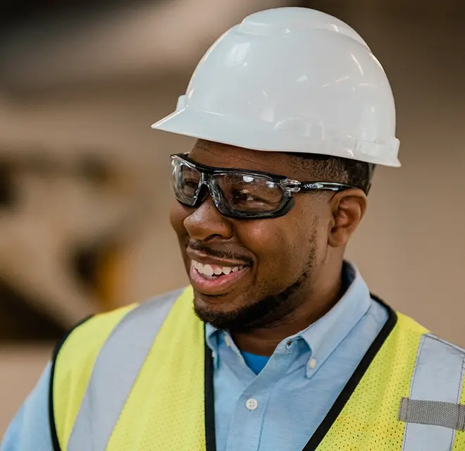 RBW tech with white hat and yellow vest smiling.