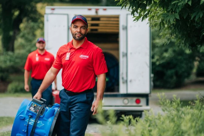 Two Rainbow Restoration specialists with truck carrying blue machine.