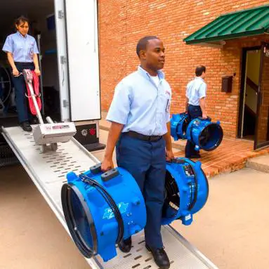 Rainbow technician carrying equipments in both hands.