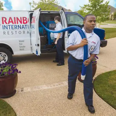 Rainbow technician holding blue hoze.