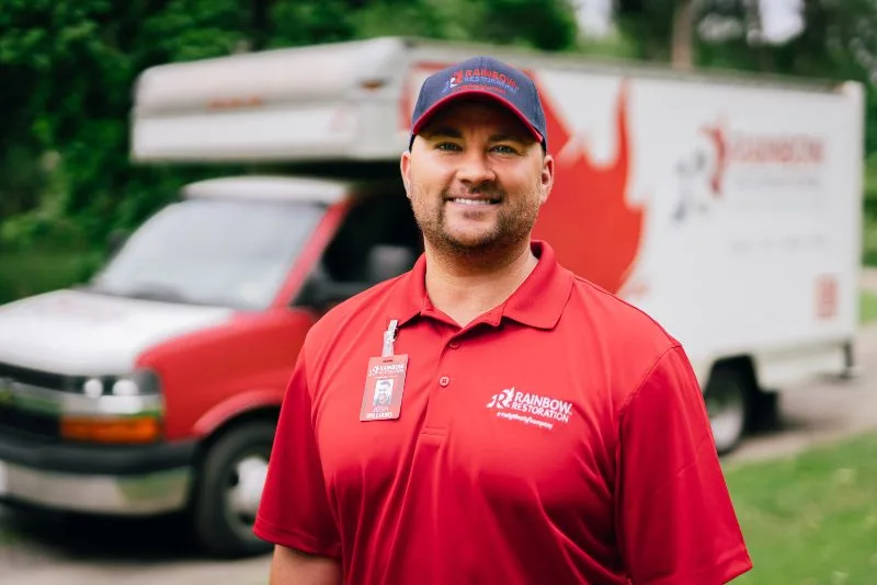 Rainbow Restoration specialist in front of his work truck ready to provide restoration services near you