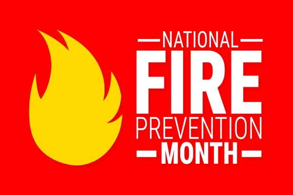 Red background with yellow flame and white lettering stating “National Fire Prevention Month".