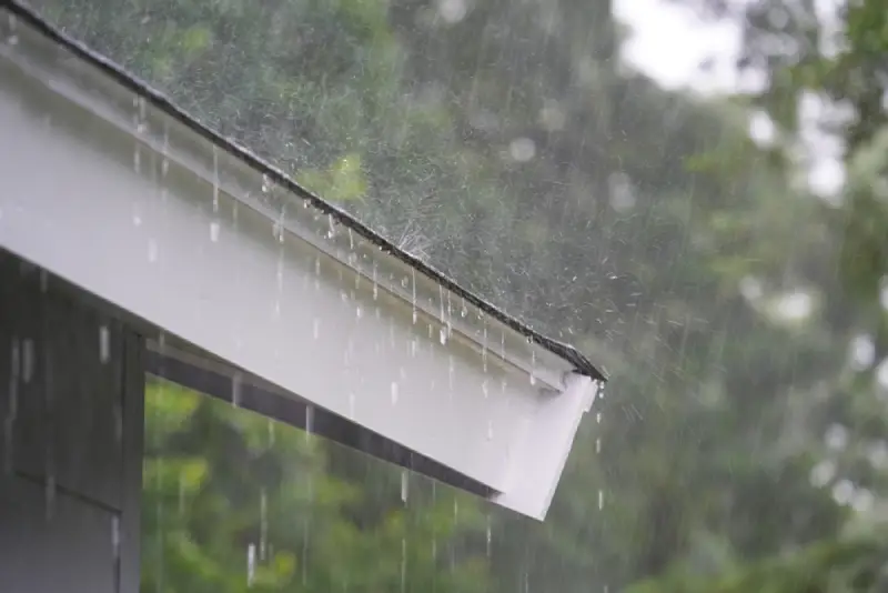 Heavy fall rainfall coming down on a home’s gutters