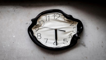 Analog wall clock burned and melted by fire in a burnt kitchen