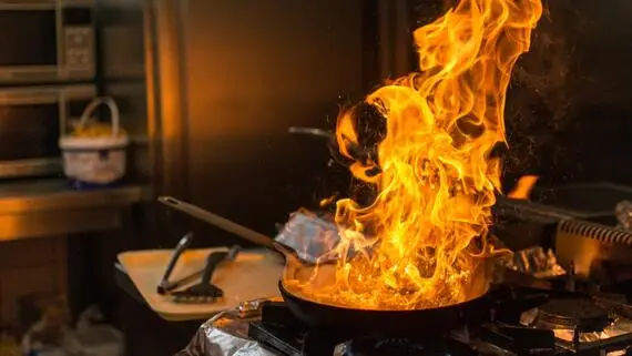 Pan on fire in a kitchen.